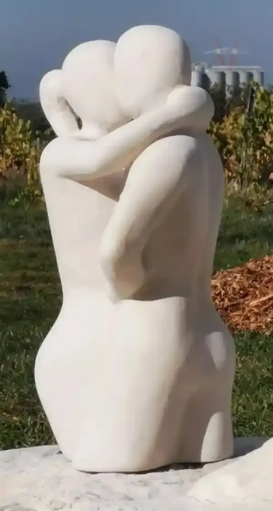 Sculpture en pierre blanche représentant un couple de danseurs vue de côté, réalisée par l’artiste Florence Boutoulle.